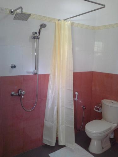 a bathroom with a shower with a toilet and a shower curtain at Supun Villa in Bentota