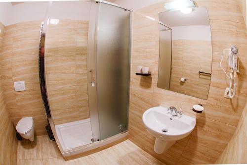 a bathroom with a shower and a sink at Hotel Kaskada in Poprad