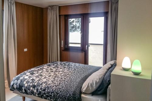 1 dormitorio con 1 cama junto a una ventana en Residence Des Alpes en Canazei