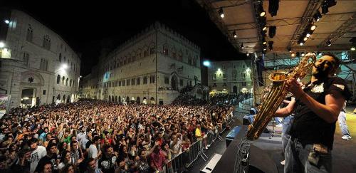 a large crowd of people watching a man playing a saxophone at B&B Alsoci-La Tasca in Marsciano