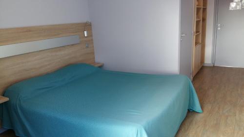 a room with a bed with a blue blanket at Les Balcons Du Velay in Monistrol-sur-Loire