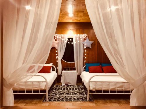 a room with two beds with curtains and a window at Farm'ily in Da Lat