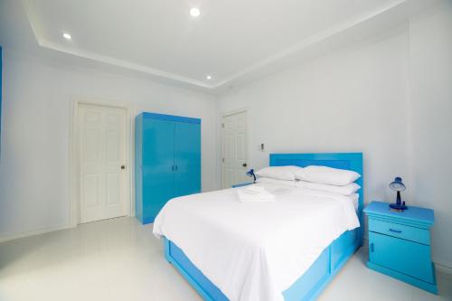 a blue and white bedroom with a bed and a blue cabinet at Bohol White House Bed & Breakfast in Lila