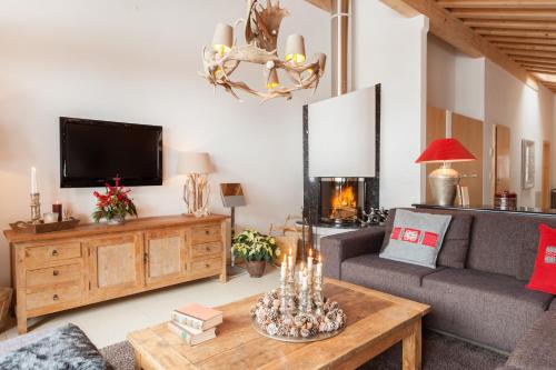 a living room with a couch and a tv at Vrony Apartments by Hotel Walliserhof Zermatt in Zermatt