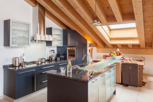 a kitchen with blue cabinets and a counter top at Vrony Apartments by Hotel Walliserhof Zermatt in Zermatt