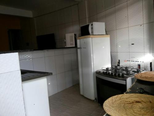 uma cozinha com um fogão e um frigorífico branco em Casa Relaxar em Salvador