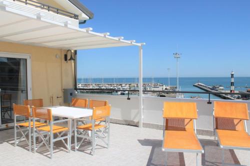 una mesa y sillas en un balcón con vistas al océano en Residence Fiorella, en Cattolica