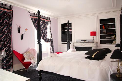 a bedroom with a bed and a red chair at Maison d'hôtes Stella Cadente in Provins