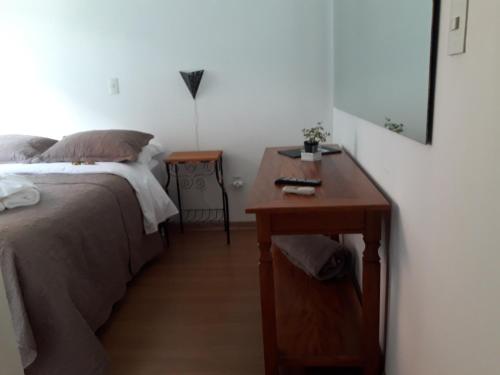 a bedroom with a bed and a wooden night stand at Pousada Vale Do Comandante in Macacos