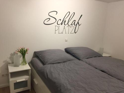 a bedroom with a bed with a sign on the wall at Ferienhaus Kluntje in Emden