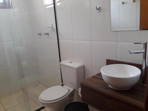 a bathroom with a toilet and a sink and a shower at Pousada Vale Do Comandante in Macacos