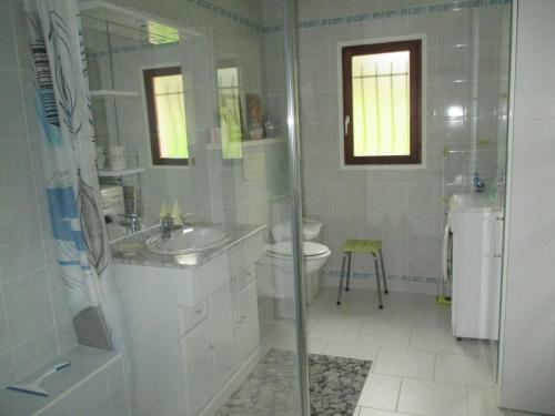 une salle de bain blanche avec un lavabo et des toilettes dans l'établissement La Griotterie, à Saint-Amand-en-Puisaye