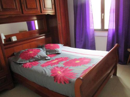 Saint-Amand-en-PuisayeにあるLa Griotterieのベッドルーム1室(ピンクの花が咲くベッド1台付)