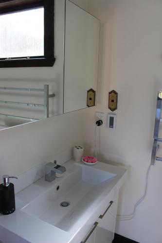 惠靈頓的住宿－Casa Felina Apartment，浴室设有白色水槽和镜子