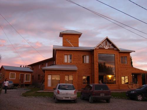 una casa con dos coches estacionados frente a ella en Hostel de Las Manos en El Calafate