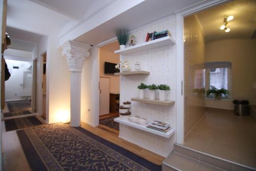 un pasillo con paredes blancas y estanterías con plantas en Guesthouse Kod Keme en Sarajevo