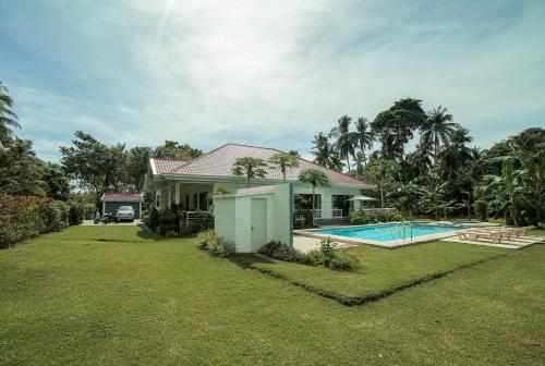 a house with a swimming pool in a yard at Bohol White House Bed & Breakfast in Lila