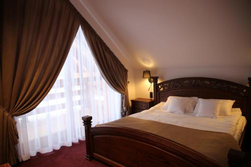 - une chambre avec un lit et une grande fenêtre dans l'établissement Dwór Kukuczka, à Istebna