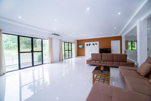 a large living room with couches and a table at Bohol White House Bed & Breakfast in Lila