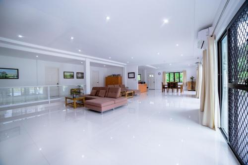 a living room with a couch and a table at Bohol White House Bed & Breakfast in Lila