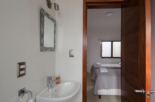 a bathroom with a sink and a mirror at Comala Bed & Breakfast in Oaxaca City