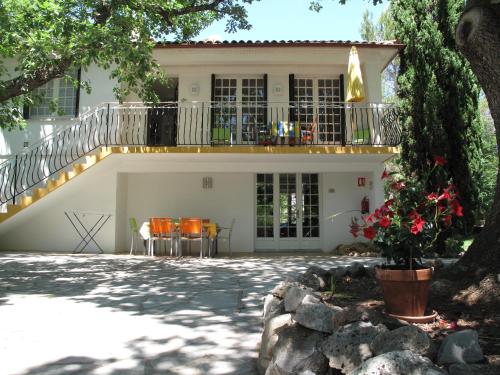 a house with a balcony and a patio at Résidence Miro, gîtes climatisés avec piscine et tennis in Les Arcs sur Argens