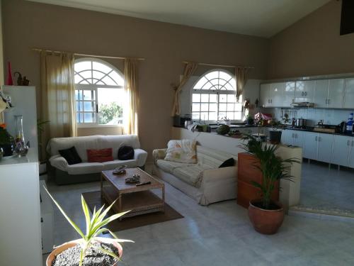 uma sala de estar com dois sofás e uma cozinha em Casa Papi em Lajares