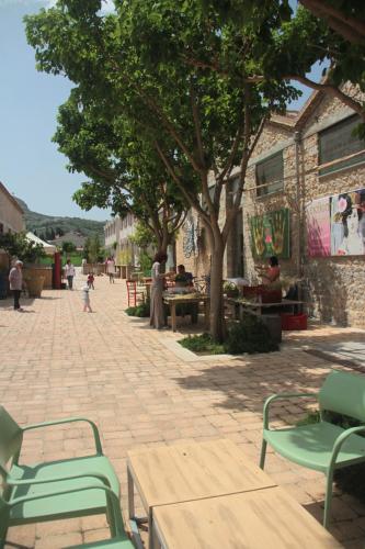 a patio with green chairs and tables and trees at Quiet spacious apartment in Nafplio in Nafplio