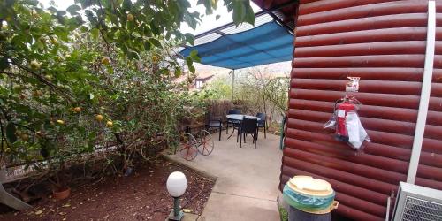 a patio with a table and chairs and an umbrella at kinneret love sounds in Migdal