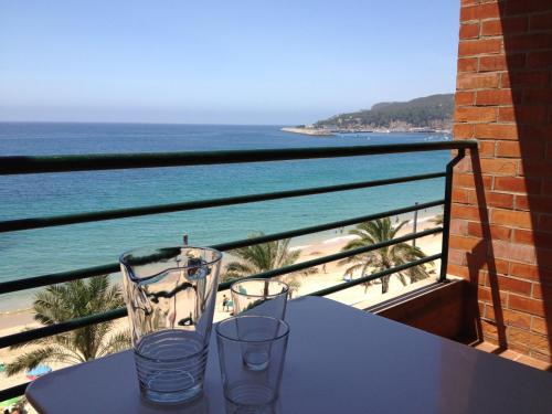 a table with two glasses on a balcony with the beach at Casa S. José in Sesimbra
