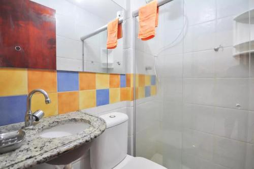 a bathroom with a toilet and a sink and a shower at Merepe Residencial in Porto De Galinhas