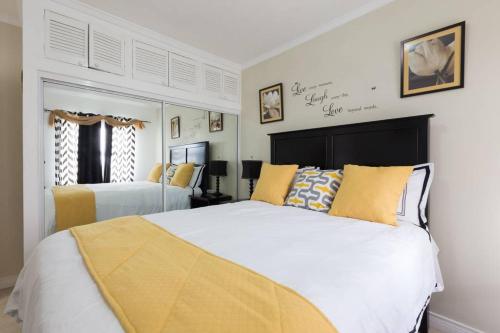 a bedroom with two beds with yellow and white at The Brompton's Luxury Apartment in Kingston