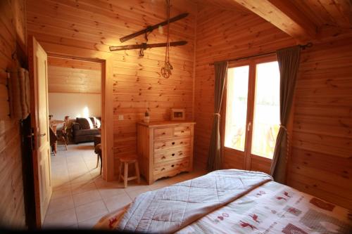 サン・ジェルヴェ・レ・バンにあるAppartement Orion à Saint Gervaisの木造キャビン内のベッド1台が備わるベッドルーム1室を利用します。