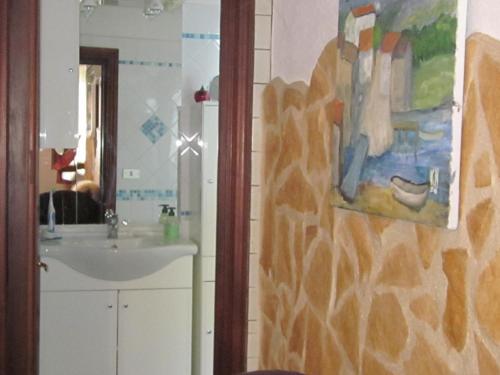 a bathroom with a sink and a painting on the wall at Bed&Breakfast Le Valli del Cerrano in Pineto