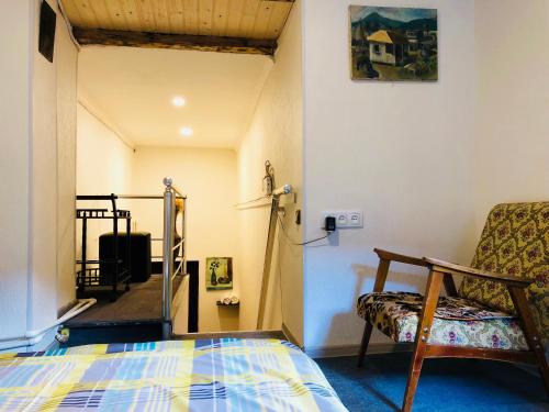 um quarto com uma cama e uma cadeira num quarto em Heart of Old Tbilisi Apartments 2 em Tbilisi