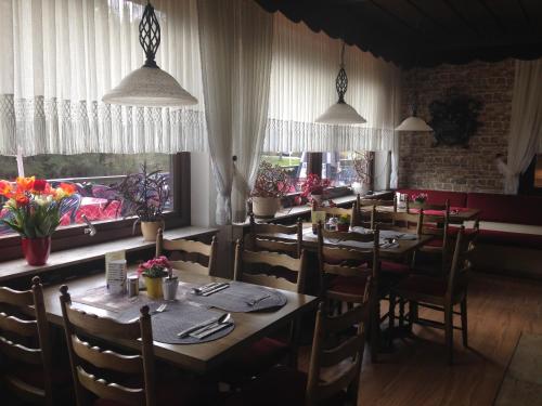 a dining room with tables and chairs and windows at Hotel Waldsee in Waldachtal