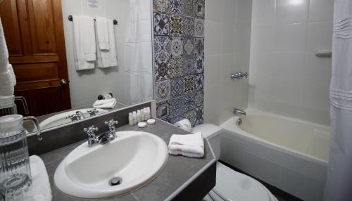 a bathroom with a sink and a toilet and a tub at Hotel Antigua Miraflores in Lima