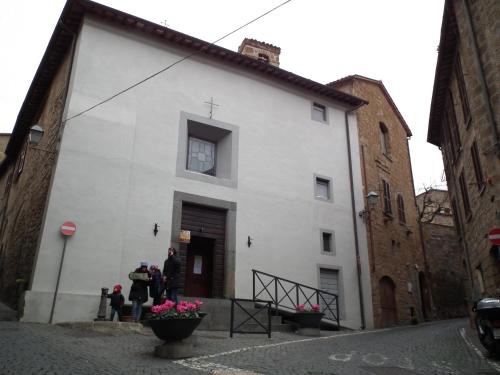 a white building with people standing outside of it at il rifugio della cava in Orvieto