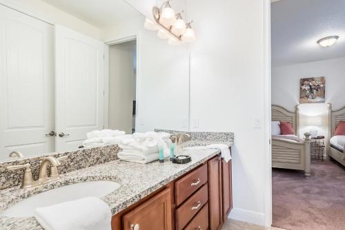 een badkamer met een wastafel en een grote spiegel bij Encore Club Orlando in Orlando