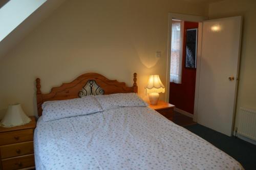 a bedroom with a bed and two lamps and a staircase at Cruachan in Cellardyke