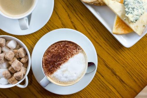 a table with plates of food and a cup of coffee at The Peacock at Barlow in Chesterfield