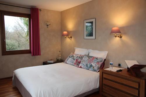 um quarto com uma grande cama branca e uma janela em Le Vallon de Saint André em Limonest
