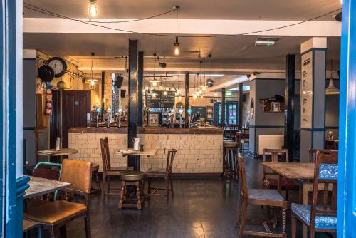 un ristorante con tavoli e sedie e un bar di Old Ship Inn Hackney a Londra