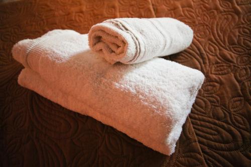 a stack of white towels on a bed at Apartments Mary in Agios Gordios