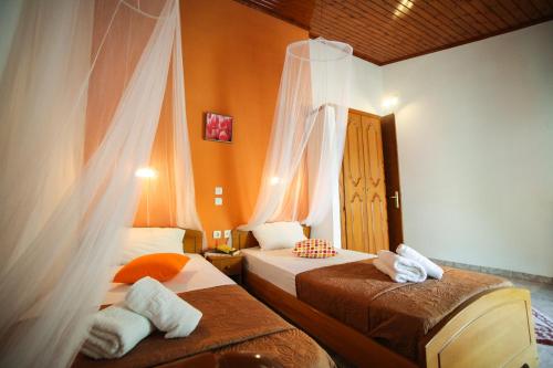 two beds in a room with orange walls at Apartments Mary in Agios Gordios