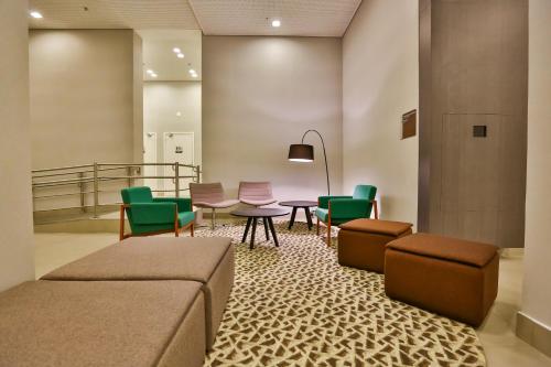 a waiting room with a table and chairs at Hilton Garden Inn Santo Andre in Santo André