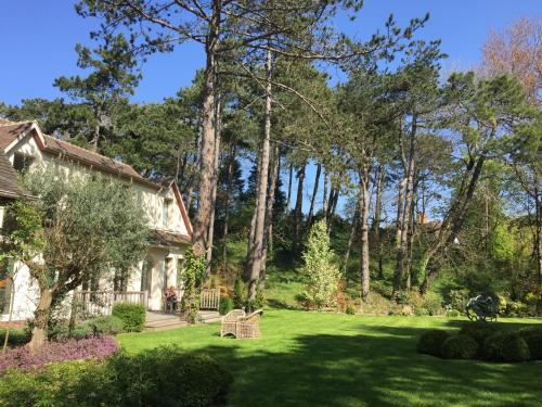 a house with a yard with chairs and trees at Demeure d'Hôtes Haec Otia in Le Touquet-Paris-Plage