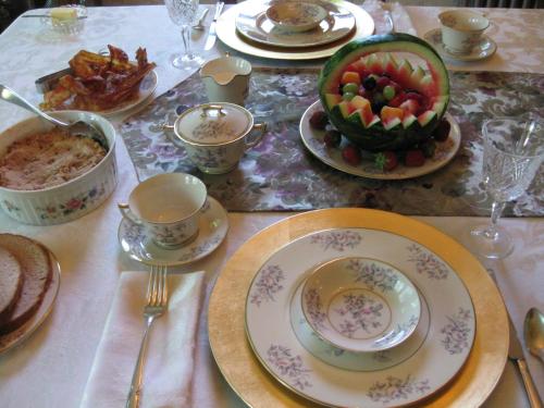 a table with plates of food and a bowl of fruit at The Bridges Inn at Whitcomb House B&B in Swanzey