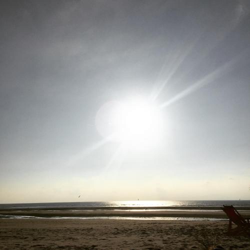 a beach with the sun shining on the water at Demeure d'Hôtes Haec Otia in Le Touquet-Paris-Plage