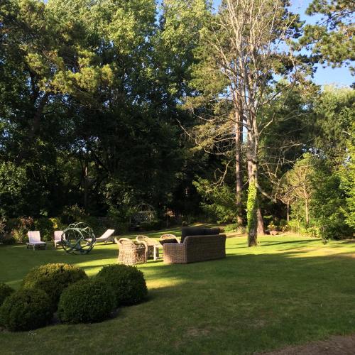 a park with chairs and tables in the grass at Demeure d'Hôtes Haec Otia in Le Touquet-Paris-Plage